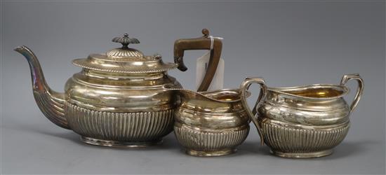 A late Victorian three-piece silver teaset, of oval half-fluted form with gadrooned edges, by HH, Sheffield